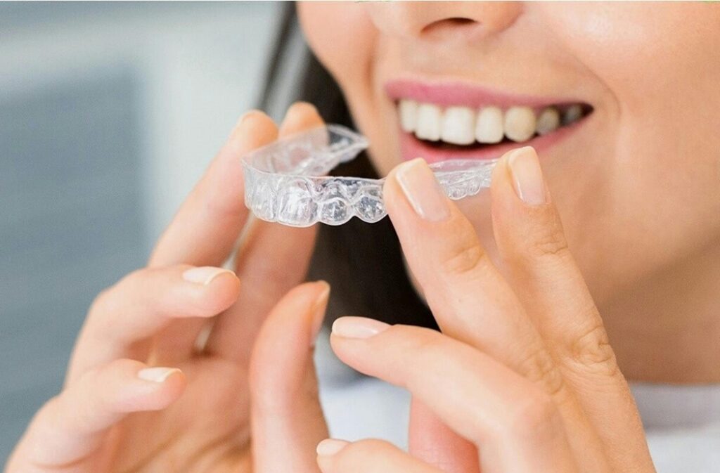 Woman putting in her invisalign to straighten crooked teeth